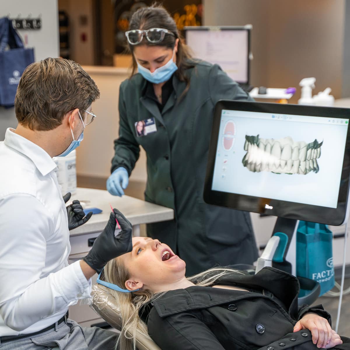 A woman is being examined by a orthodontist in a dental office.
